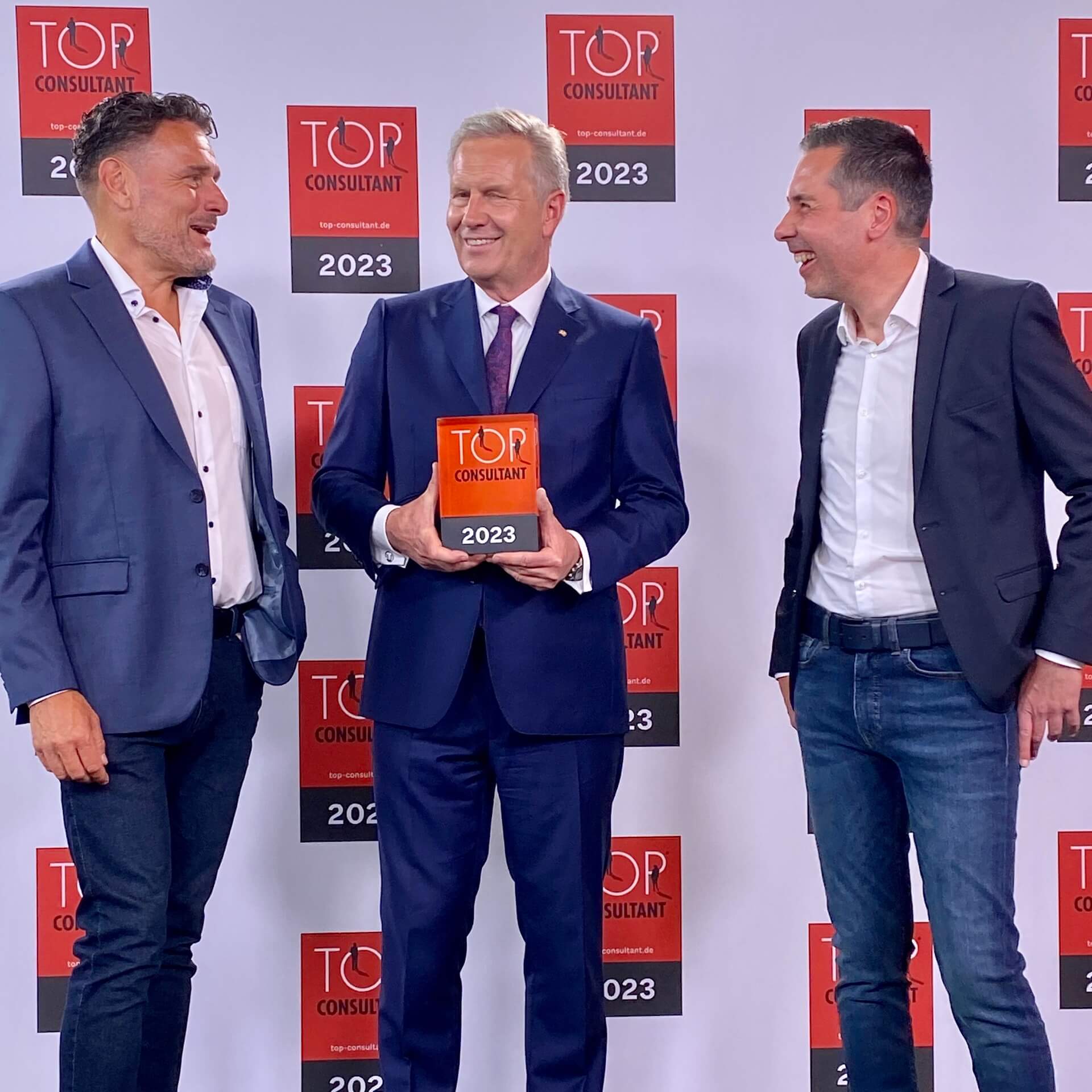 Andreas Straehler und Dennis Fischer von WACHSTUMSPLAN GmbH gewinnen TOP CONSULTANT 2023 lustig bei Preisübergabe von Christian Wulff